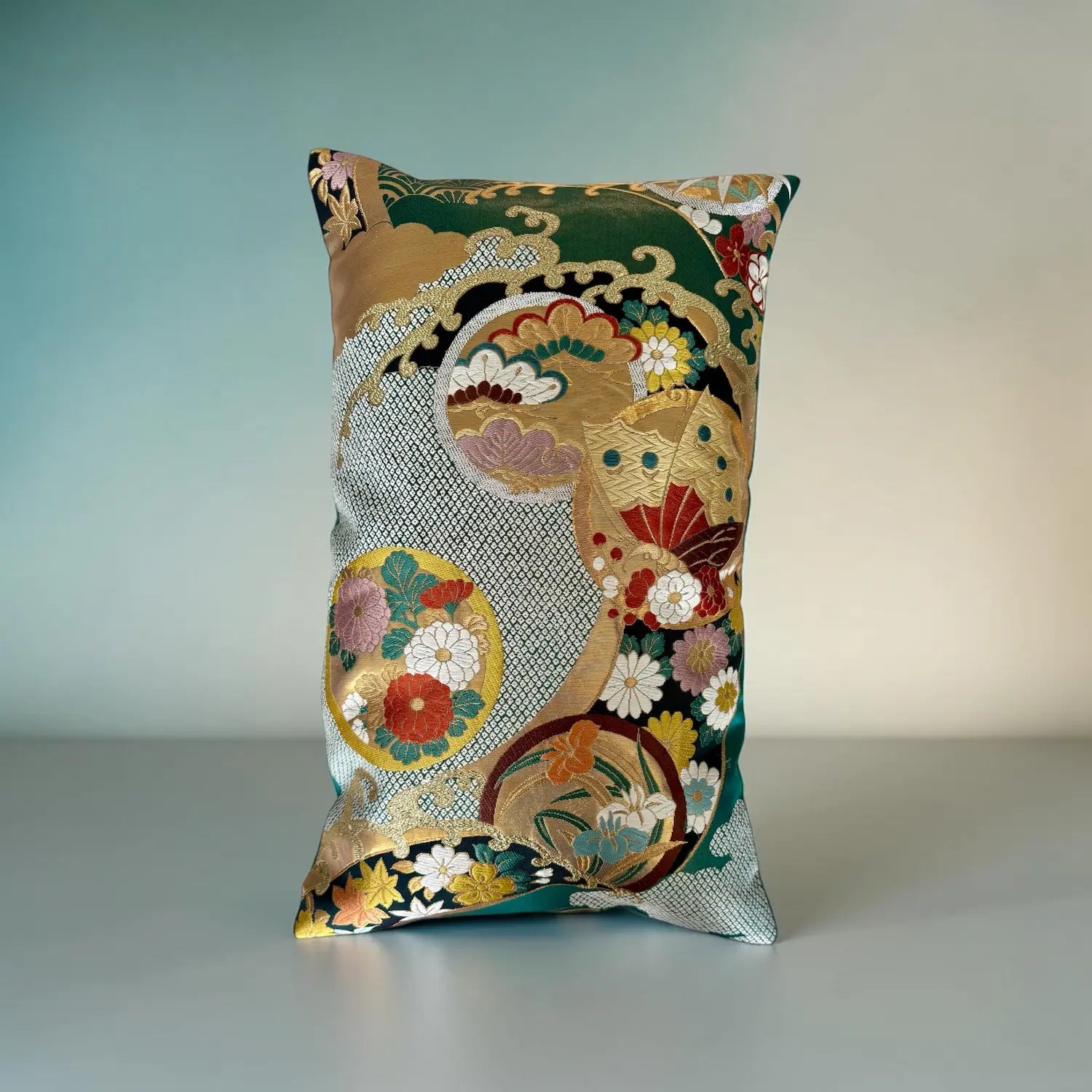 Decorative cushion with intricate floral and geometric pattern on a plain background