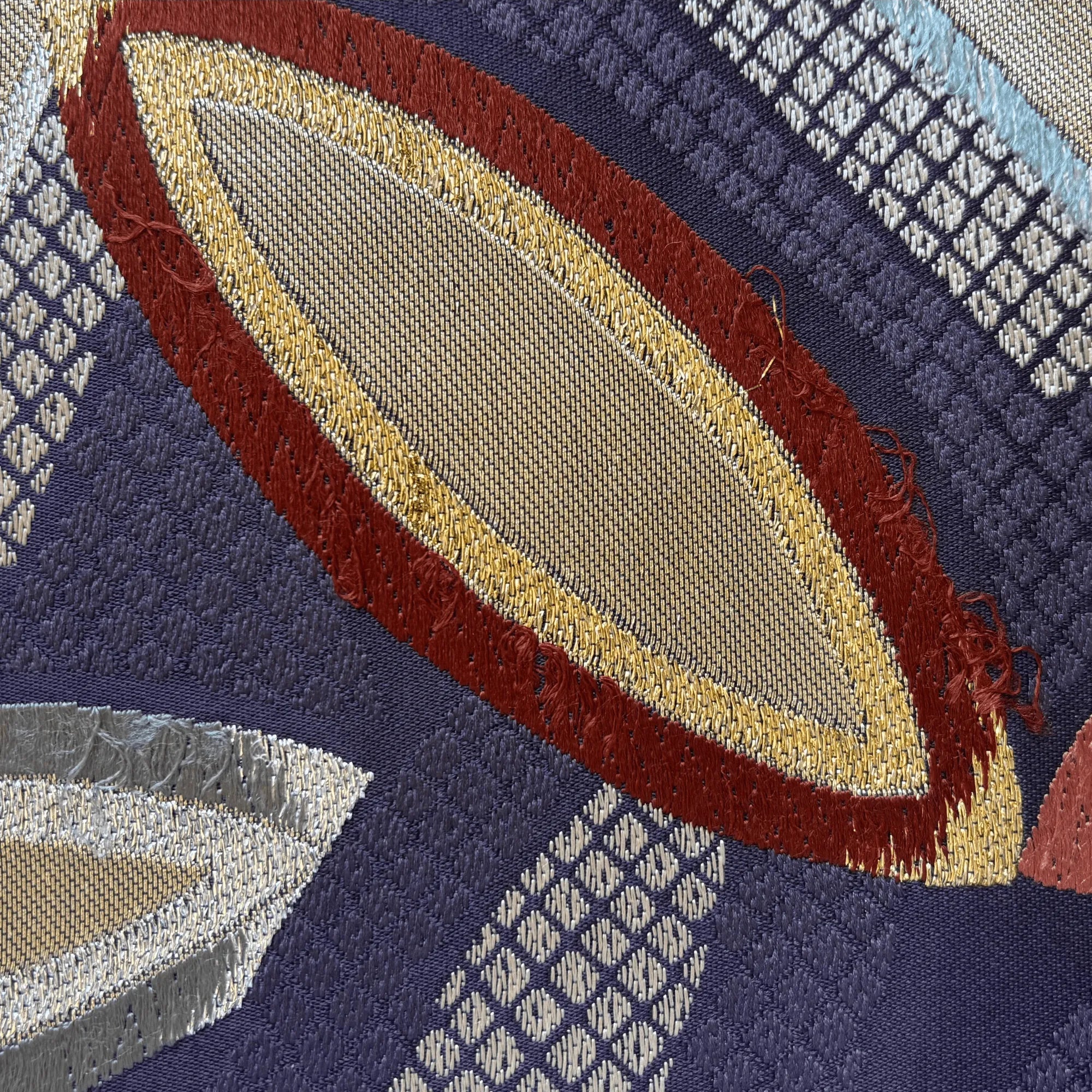 Close-up of a silk fabric with geometric patterns and colors.