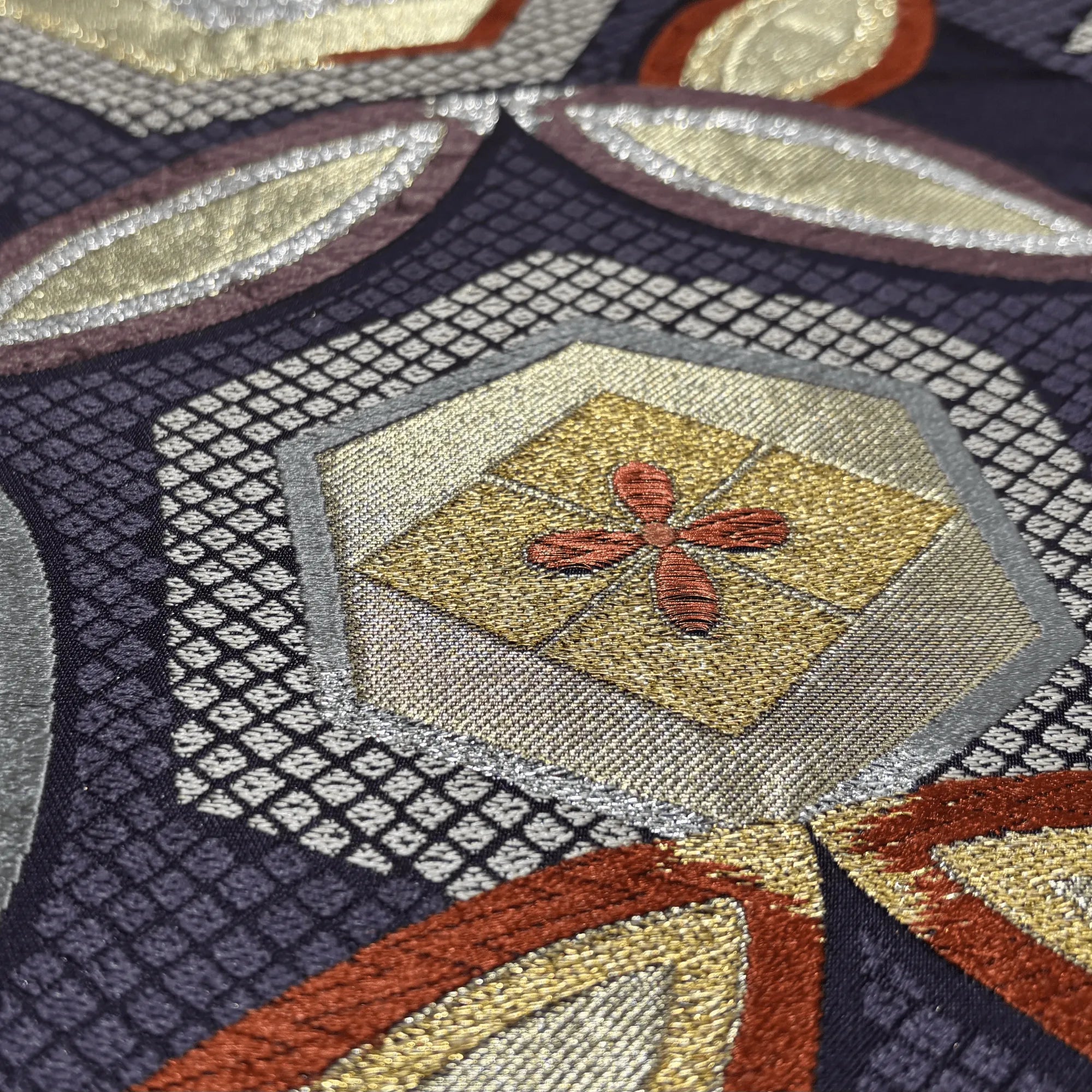 Close-up of an intricately patterned silk with geometric shapes and a central design.