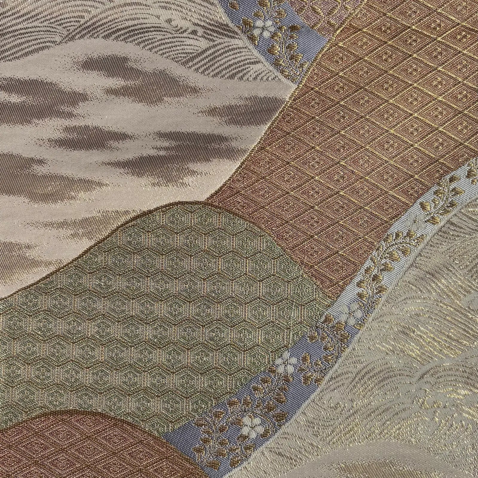 Close-up of a fabric with intricate patterns in brown, beige, and blue.