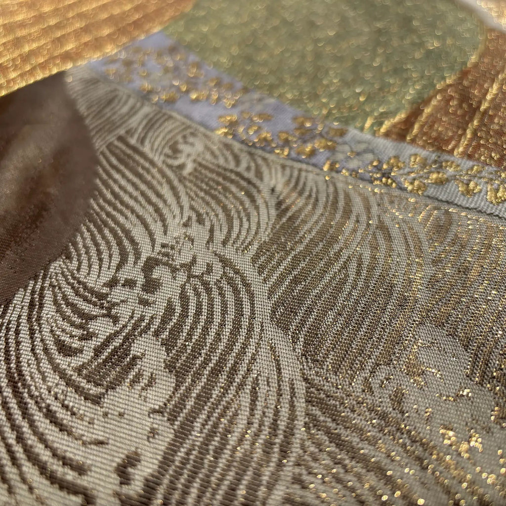 Close-up of textured fabric with gold accents and intricate patterns.