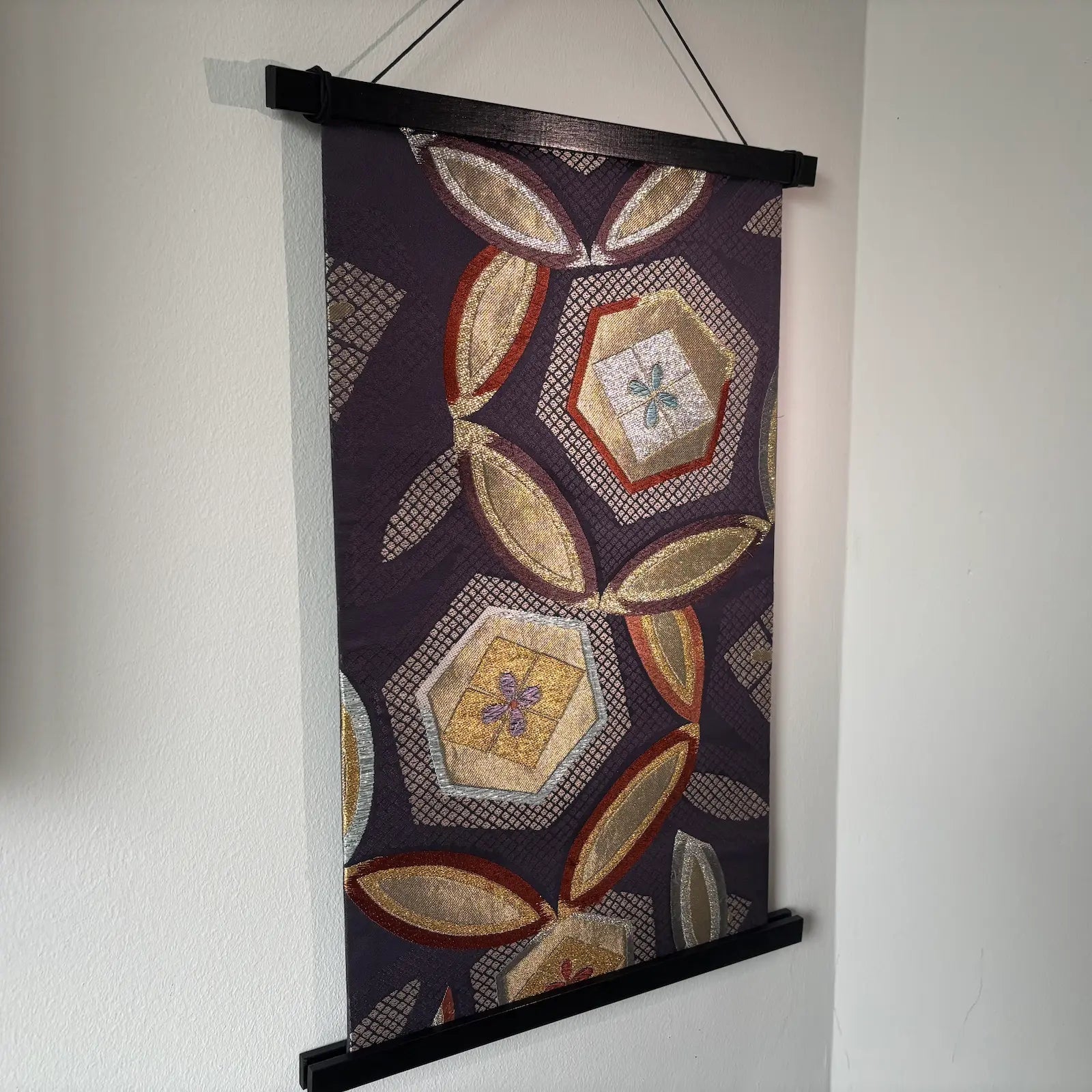 Decorative wall hanging with geometric pattern on a plain background