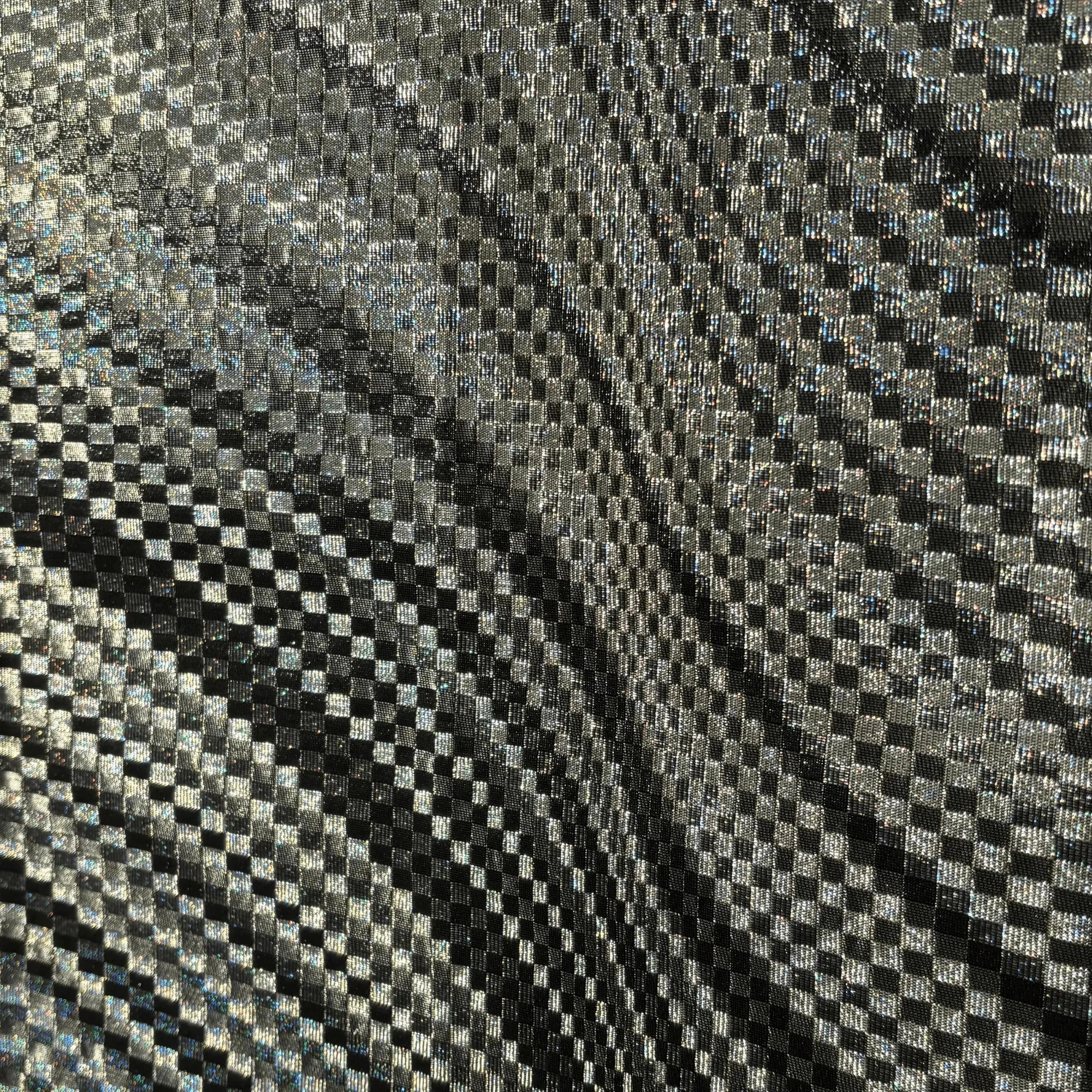 Close-up of a textured fabric with a checkered pattern in black and silver.