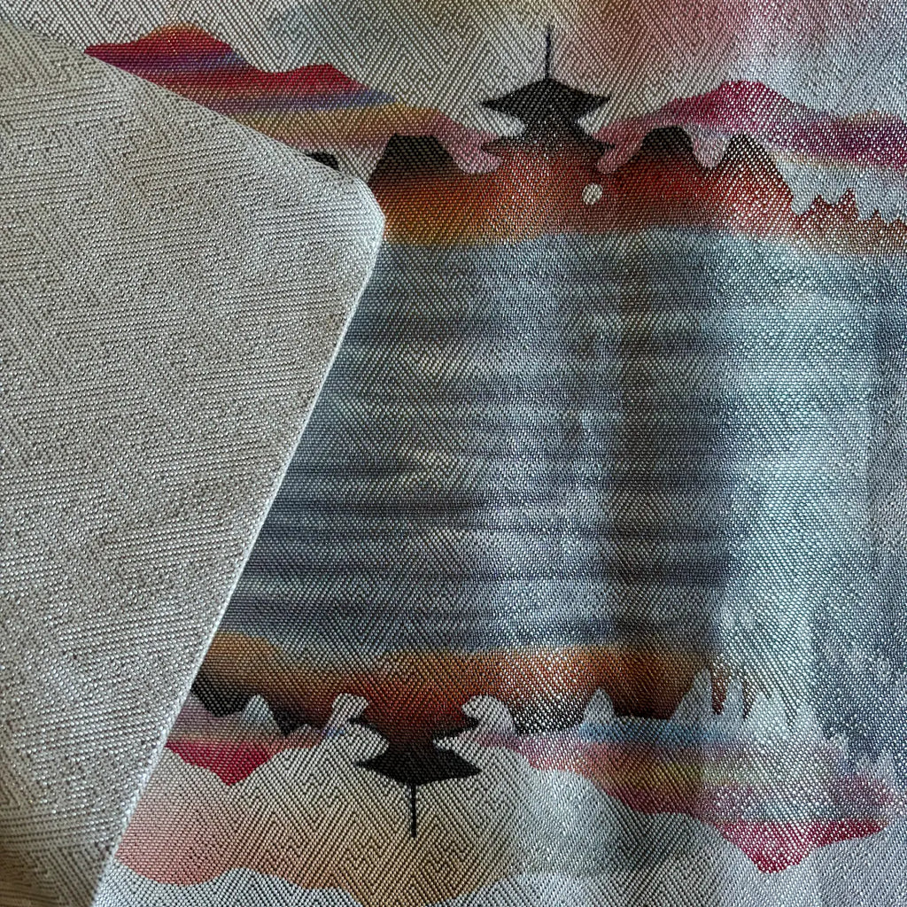 Silk runner with geometric pattern featuring triangles and a central design on a textured background
