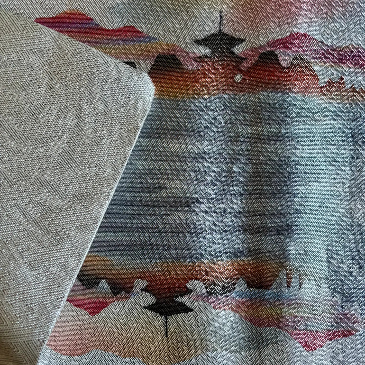 Silk runner with geometric pattern featuring triangles and a central design on a textured background