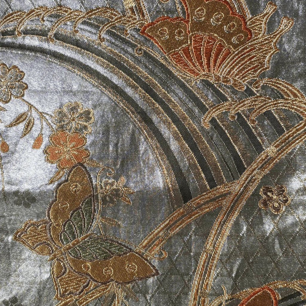 Close-up of embroidered fabric with butterflies and flowers on a textured background