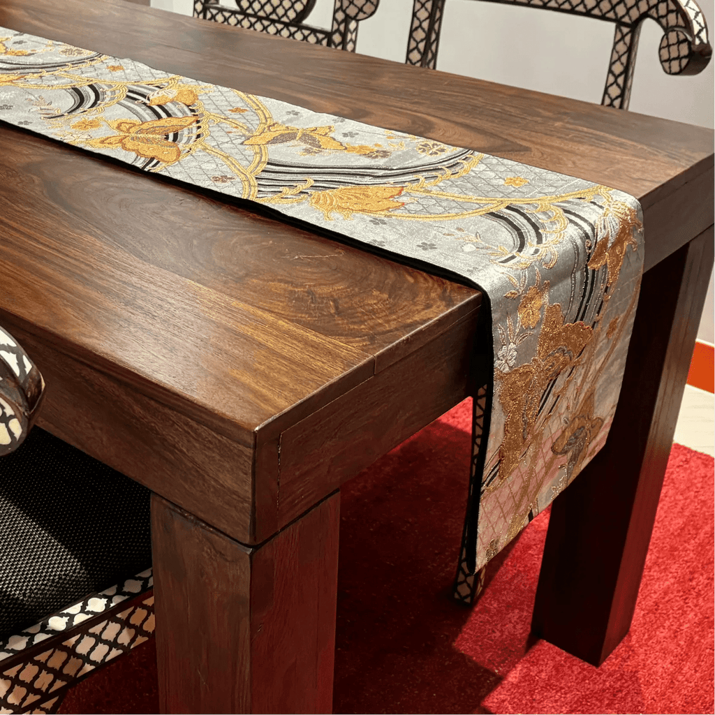 Wooden table with a decorative table runner on a red carpet