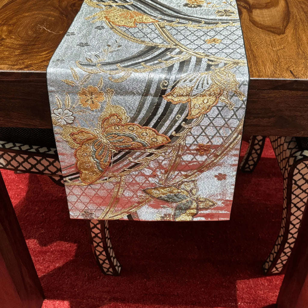 Decorative table runner with butterfly design on a wooden table