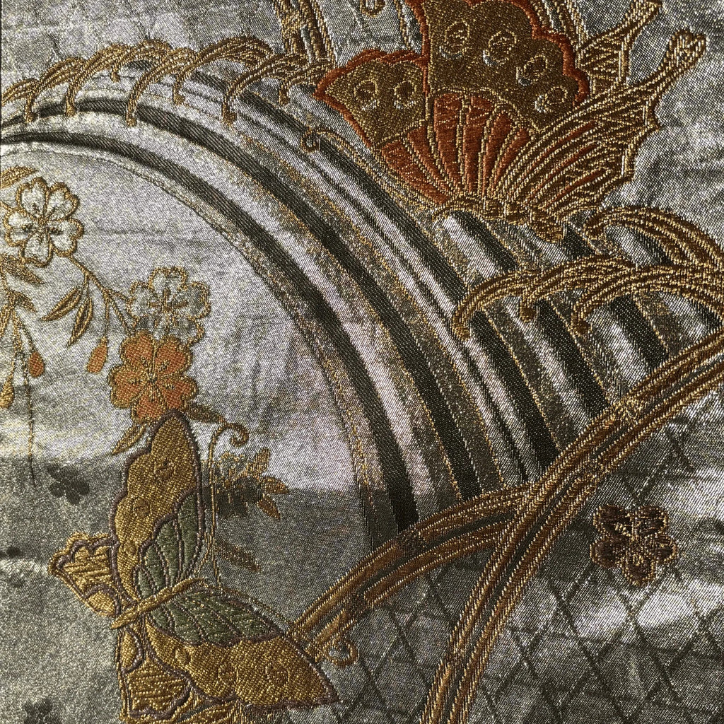 Close-up of embroidered floral design on fabric with a rainbow.