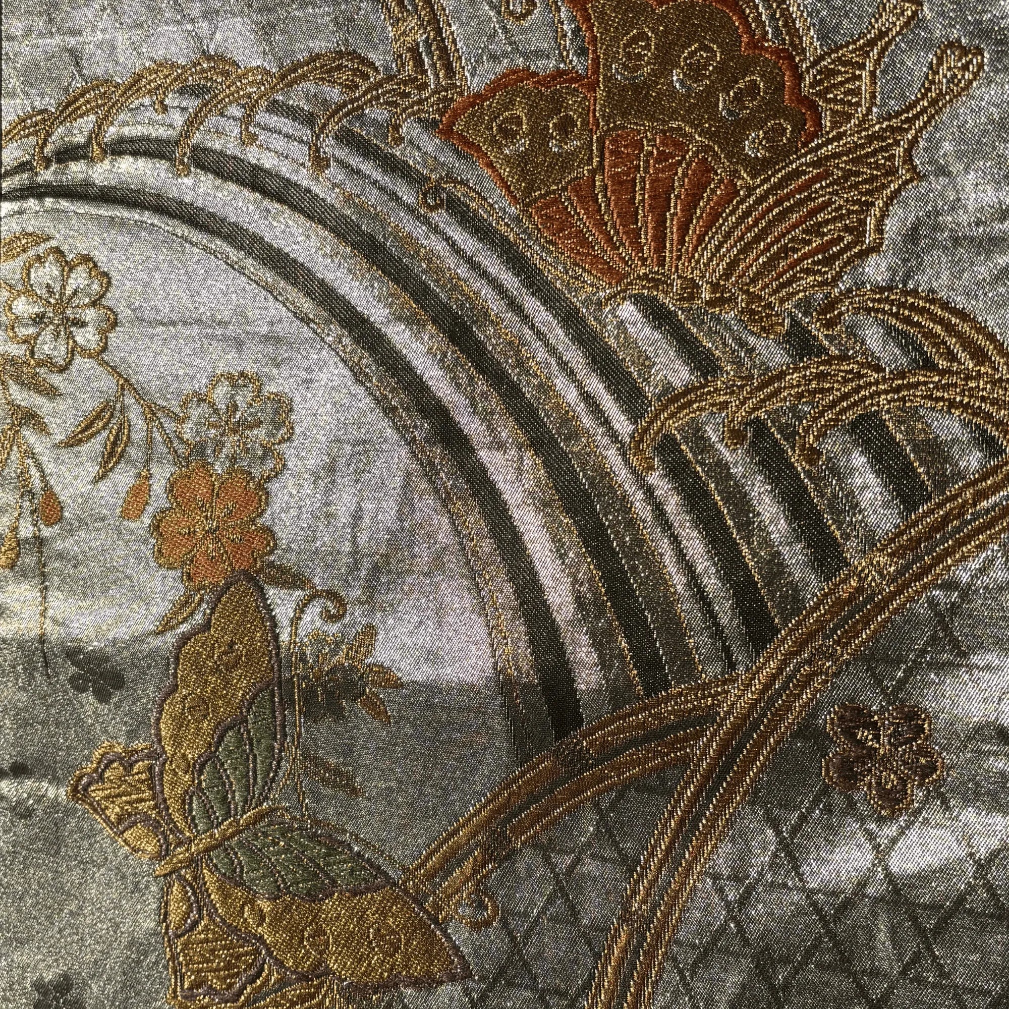 Close-up of embroidered floral design on fabric with a rainbow.