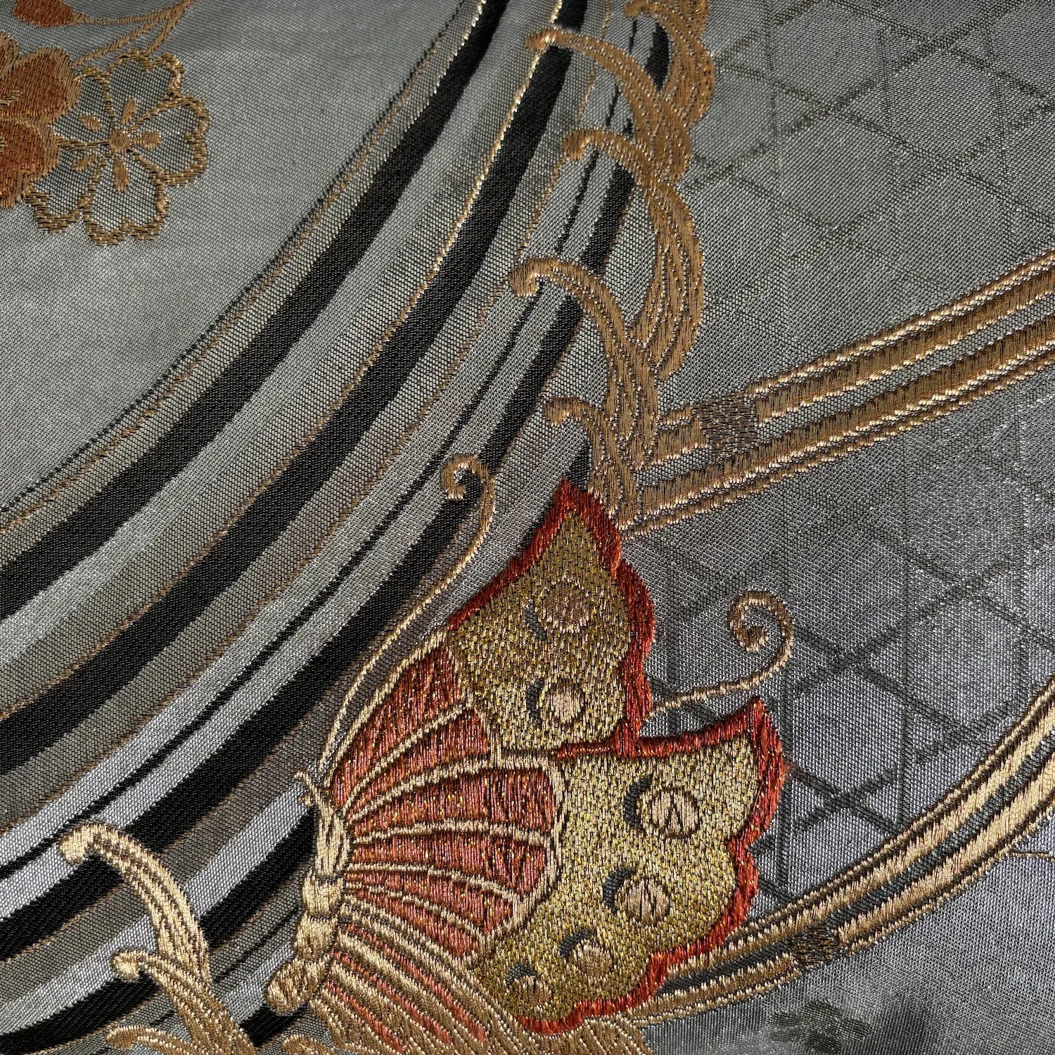 Close-up of embroidered fabric with butterfly design on a silver background