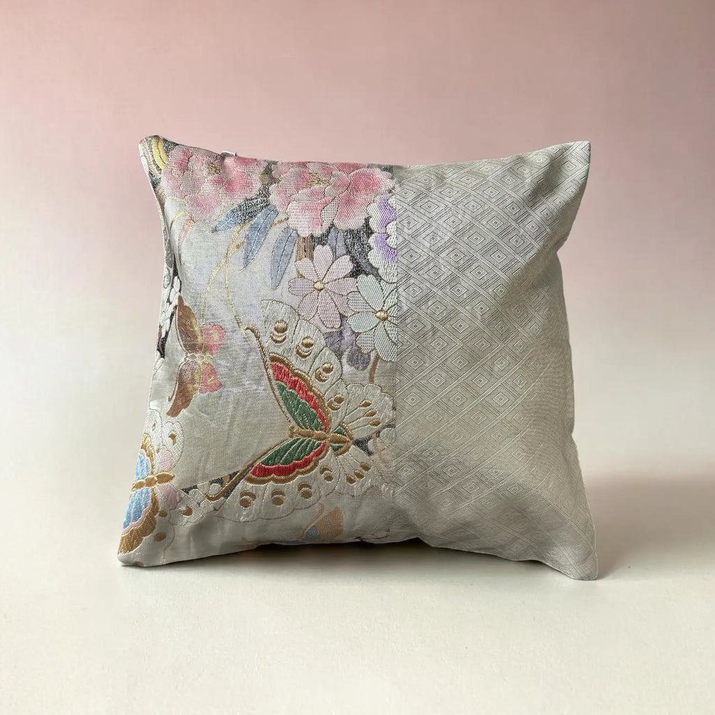 Decorative cushion with floral and butterfly pattern on a pink background